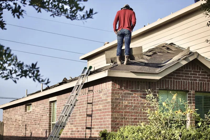 Professional roofer working on a residential roof in Waban